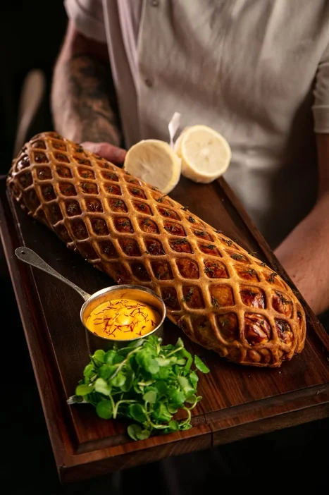 A lattice-topped pastry presented on a wooden board