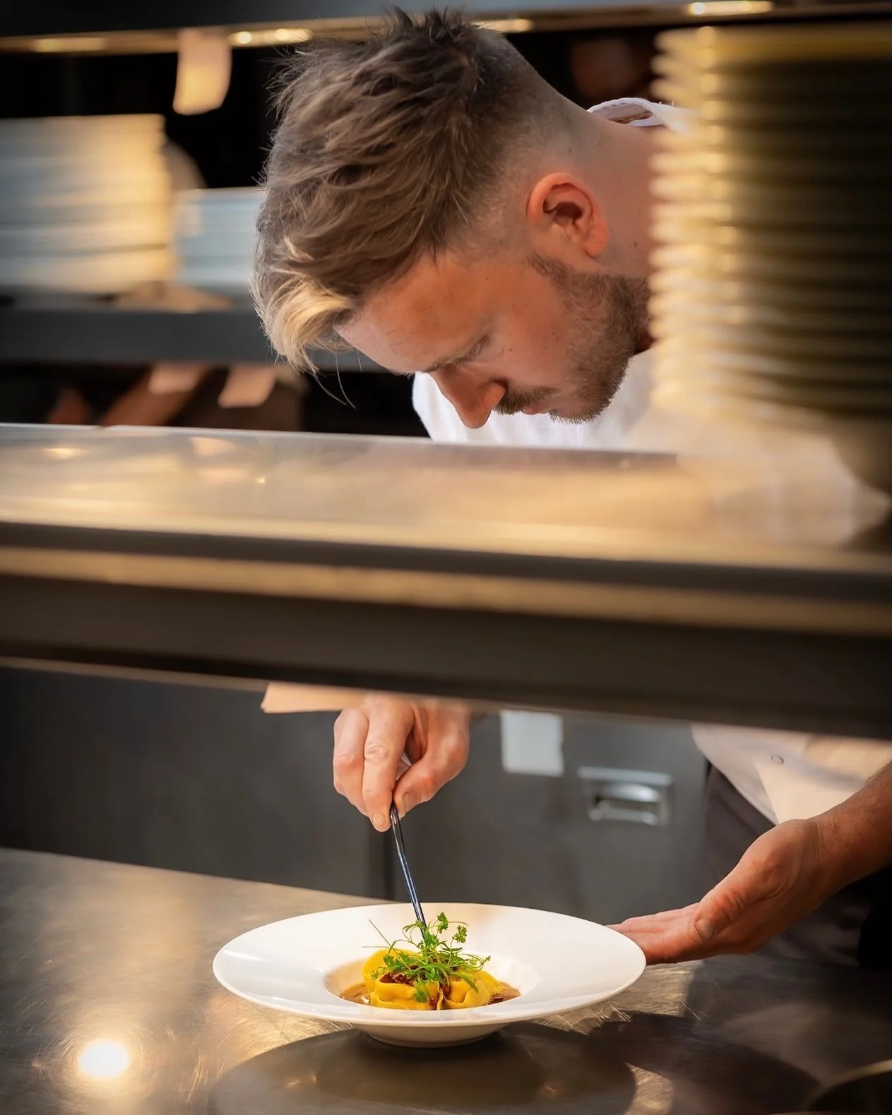 Jack Smith finishing a plate at the kitchen pass